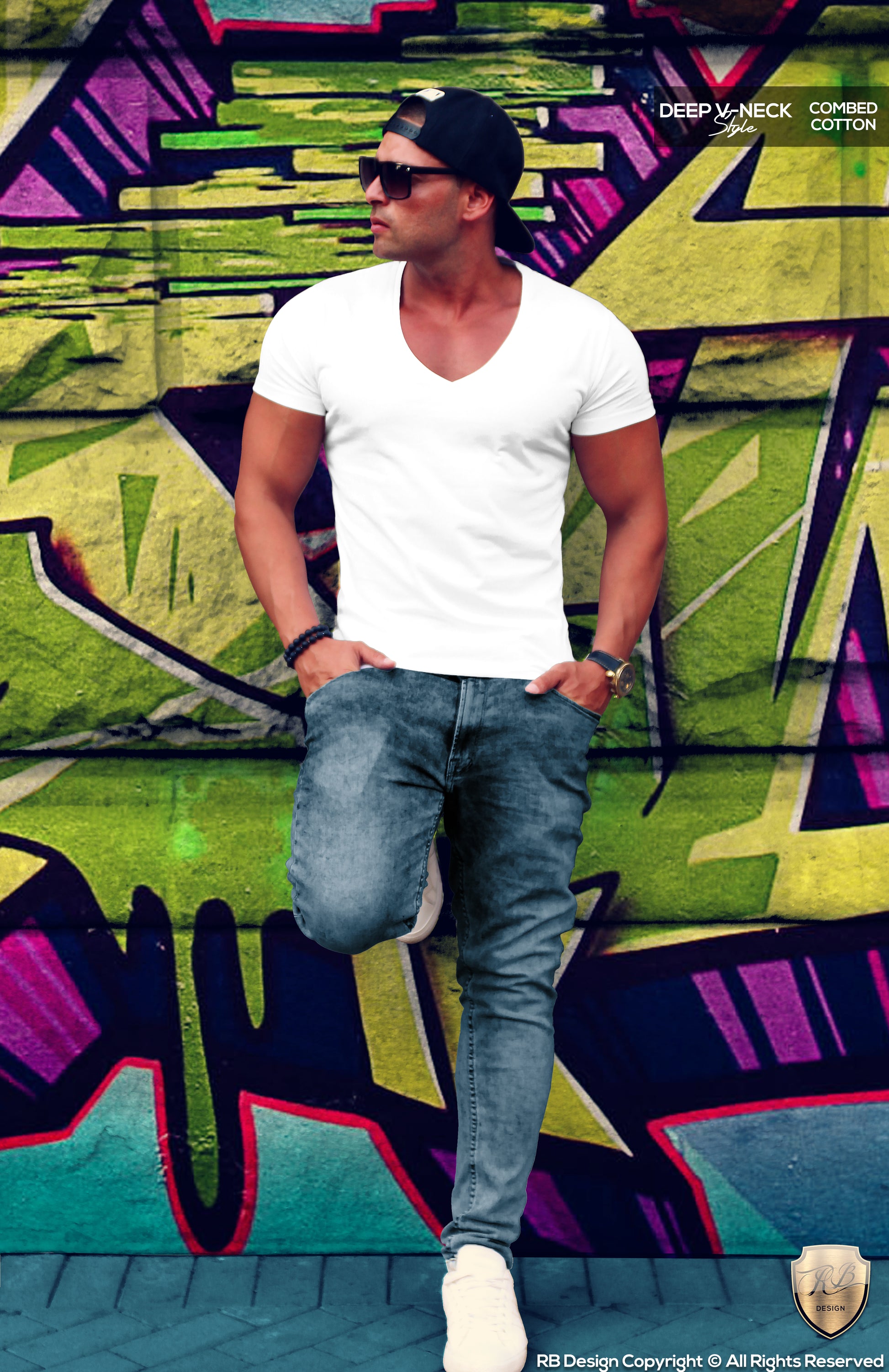 A man wearing a plain white deep V-neck T-shirt and blue jeans, standing in front of a colorful graffiti wall.